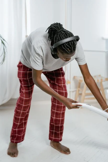Un couple range leur salon, en réorganisant les meubles et les tapis en équipe.